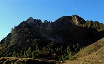 La meta del giorno è il monte Naiarda (1899m). Cima modesta ma selvatica, che si presenta più abbordabile dalle pendici visibili dal lato di forcella Naiarda. Seguendo in discesa il sentiero si osservi il monte. Presenta sulla destra una placca rocciosa e