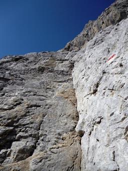 Attacco della fascia rocciosa. Ci si può discostare leggermente dai segnavia per procedere su tratti di arrampicata più elementari.