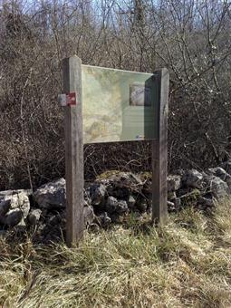 Lo sterrato conduce dopo alcune decine di metri al sentiero d'accesso ad una dolina con un grande tabellone informativo.