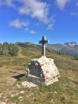 Una breve deviazione a destra conduce alla vetta del Monte Spina (1967), caratterizzata da un cippo sovrastato da una croce marmorea ed un vasto panorama sulla Catena Carnica Principale.