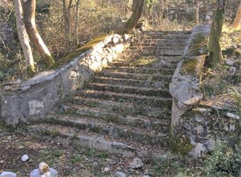 Ignorando alcune diramazioni secondarie, proseguiamo il cammino, raggiungendo con un ampio arco a destra l'inizio di una monumentale scalinata.