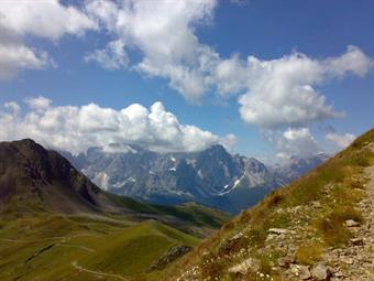 Dall'importante crocevia di sentieri imbocchiamo a destra la mulattiera CAI 160 che, con comodi tornantini nel tratto intermedio nella zona delle Pale del Rio Negro, ci porta sulla cresta di confine alla sella dei Frugnoni, dove il panorama sulle Dolomiti