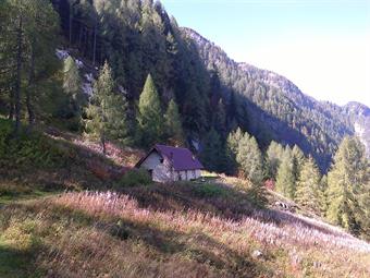 Avvicinamento: Vedi relazione citata.<br /><br />Descrizione: Dal parcheggio seguendo la carrareccia e le indicazioni per il rifugio Gilberti, nell'area occupata un tempo dal campetto di calcio, trova oggi collocazione la stazione di partenza della nuova 