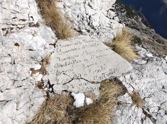 Vicino al contenitore del libro di vetta troviamo un'iscrizione riportante i nominativi di alcuni alpini, probabilmente impegnati nella costruzione del monumento celebrativo.