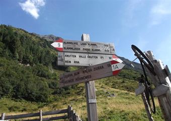 Un cartello con alcuni errori ortografici ci informa sulla possibilità alternativa di raggiungere la Durraalm/M.ga Dura lungo la Reinerhohenweg/Via Alta di Riva.