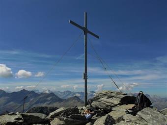 La vetta del Dreieck Spitz/Triangolo di Riva a 3031 metri di quota ospita una grande croce metallica, fornita di contenitore con il libro delle firme ed un panorama straordinario.
