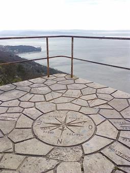 Si continua con breve tratto sentiero 1 + sentiero nel bosco (tratteggiato in nero sulla carta) fino al monte San Primo, 278 mt., Vedetta Slataper con la rosa dei venti: ampio panorama sul golfo di Trieste, Miramare, foce dell'Isonzo e Istria.