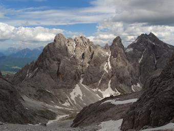 Giunti all’esigua forcella la vista s’apre sulla cima di Padola e la Croda di Tacco. Per raggiungere il bivacco Gera ci si cala per un altro trampolino ghiaioso, ove spesso il troi è inesistente. La discesa è malagevole e può esser interpretata a piacere.