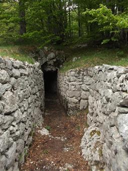 Un tratto di trincea scavato interamente nella roccia ci porta all'ingresso di una breve galleria, fornita di feritoia per mitragliatrice e percorribile  con l'ausilio di un' adeguata torcia frontale.