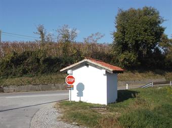 Tralasciando a destra la sconnessa carrareccia non segnalata fra i vigneti, proseguiamo lungo la rotabile asfaltata, uscendo in breve dal paese, fino all'incrocio successivo, nei pressi della fermata dell'autobus.