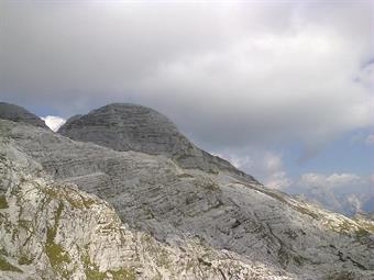 Alla nostra sinistra l'inconfondibile sagoma della Cima Confine chiude la lunga dorsale proveniente dalla Sella Prevala.