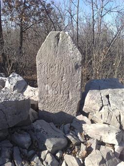 Percorse poche decine di metri verso ponente una traccia poco marcata a destra conduce alla sommità boscosa del Goljak, dove reperiamo un'antica stele confinaria risalente al 1818.