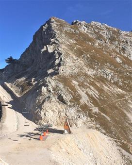 Una breve discesa conduce alla Sella Prevala, recentemente sventrata per la realizzazione del collegamento invernale fra le stazioni sciistiche italiana e slovena, operanti sui versanti opposti del gruppo del Monte Canin.