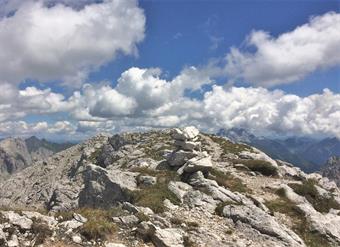 Seguendo ora la relazione "Monte Lastroni e Laghi d'Olbe" presente in questo sito, raggiungiamo l'estremità occidentale del Monte Lastroni, caratterizzata da un piccolo ometto di sassi.