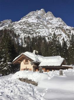 Un lungo rettilineo conduce al Pian delle Bombarde, dove si trova la Baita Rododendro, aperta durante al stagione invernale, sovrastata dal Monte Lastroni.