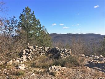 Sulla vetta dello Školj (218) si trova una grande spianata, in parte limitata dalla vegetazione arborea, con alcune panchine ed una postazione italiana ricostruita, diretta verso il Flondar ed il Monte Ermada. 