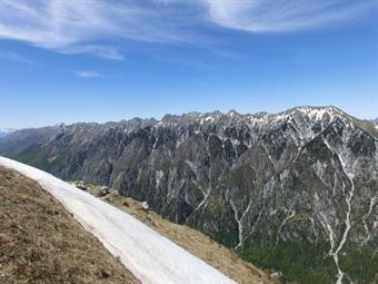 A sella Kriz seguo la traccia e poi delle orme nella neve in leggera discesa. Mi fido. Sono chiare. Svolto lo sperone roccioso ed eccolo là il rifugio! Nascosto dai rami, come miraggio. Così è. Il casermone è inarrivabile. Devo risalire il crinale che fur